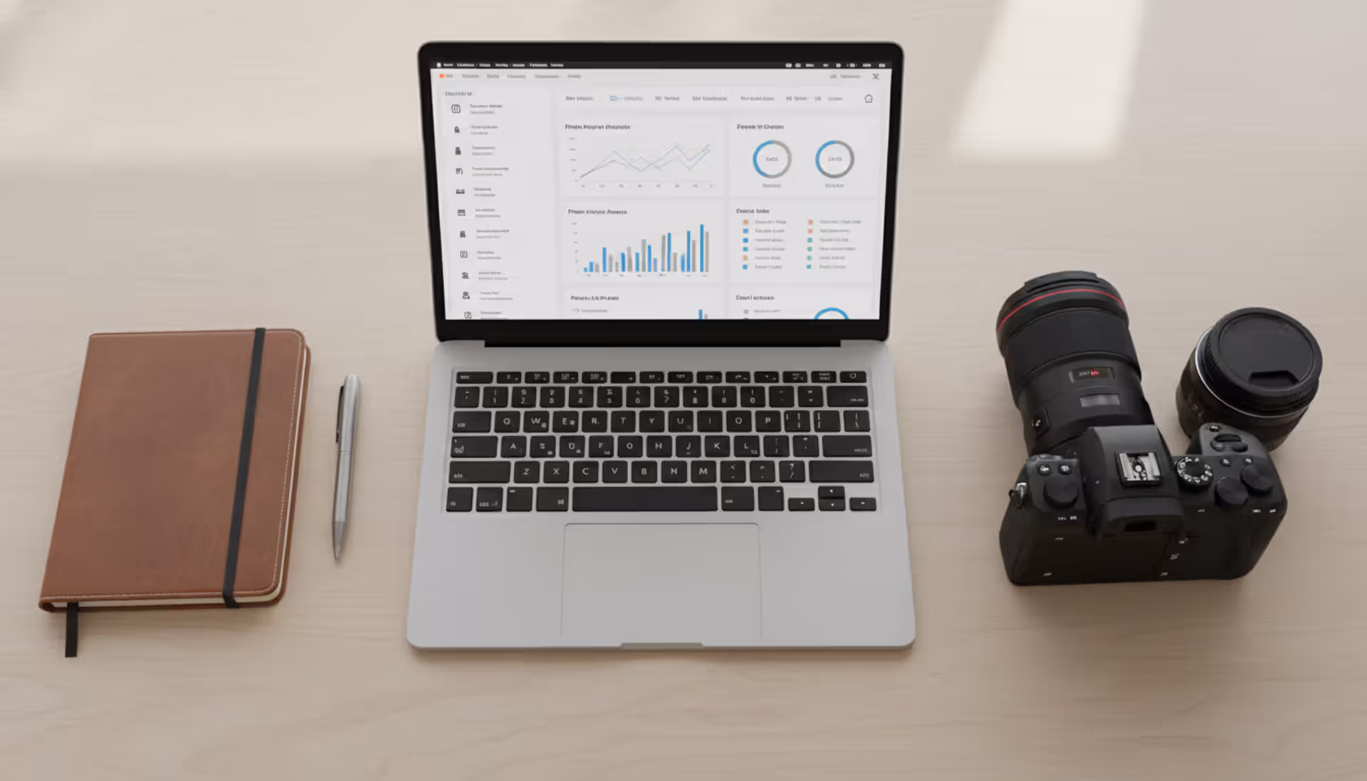 Photographer workspace with laptop showing analytics dashboard and professional camera on a clean wooden desk